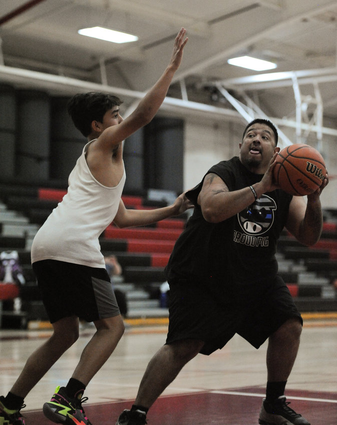 Officer Gabe Vasquez of Brighton police goes one-on-one against Preston Vigil, 13, of Thornton, during Brighton PD's Youth Services 3-on-3 basketball event June 17, at Brighton High School.
